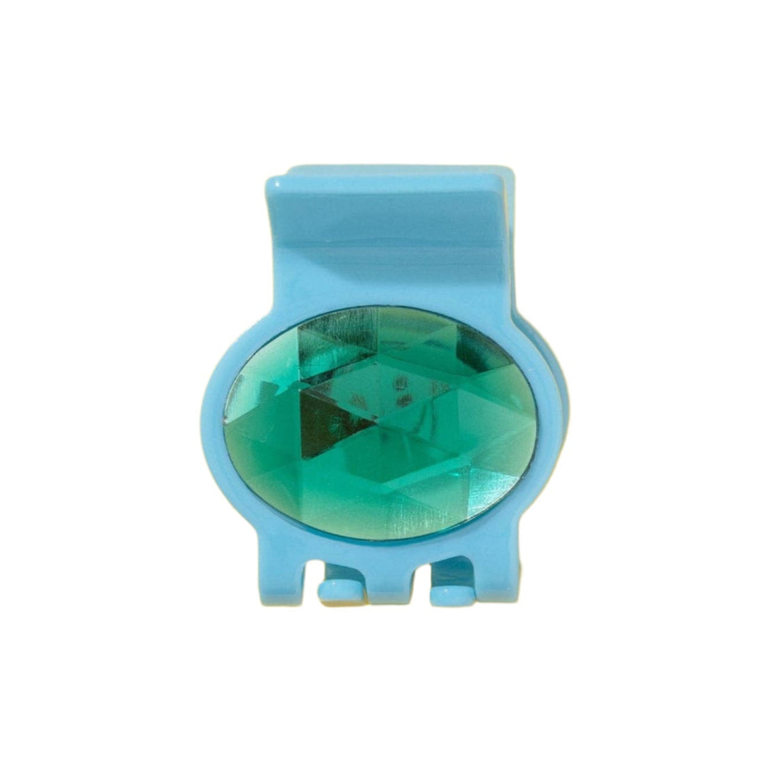Blue hair clip with a green gemstone on a white background