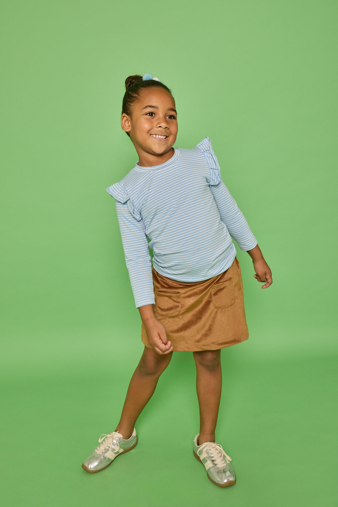 Model can be seen wearing a long sleeve blue and white strip knit top that features a fun ruffle detail at sleeve. Pair it back with our brown faux suede skort that features built in shorts and pockets in the front for an elevated look. 
