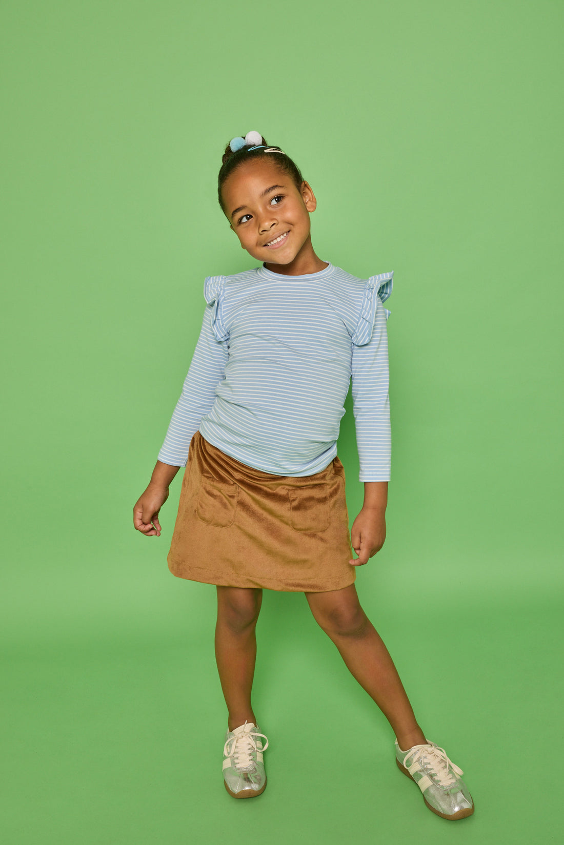 Model can be seen wearing a long sleeve blue and white strip knit top that features a fun ruffle detail at sleeve. Pair it back with our brown faux suede skort that features built in shorts and pockets in the front for an elevated look. 