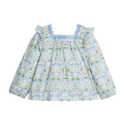 Woven long sleeve square neck top that features a light blue ribbon detail along neckline and elastic cuffs at sleeves for a relaxed but secure fit. Top is also seen to be in  a gorgeous blue/green/white floral pattern.