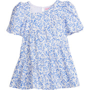 Girls/Tween woven dress in a royal blue and white floral pattern. Dress features a fun asymmetrical hem which adds a fun feature to the dress. Dress also has slight puff sleeves and also has a keyhole button closure on back of neckline. 