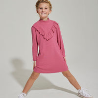 Little girl can be seen wearing out Aspen Dress in our Cranberry Metallic Stripe. It has an asymmetrical ruffle  in the front and is long sleeved as well--BISBY girl