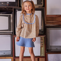 Little girl can be seen wearing our Chelsea Top in our Devon Floral Amber which we have paired with our Mini Skirt in French Blue Sherpa--BISBY girl