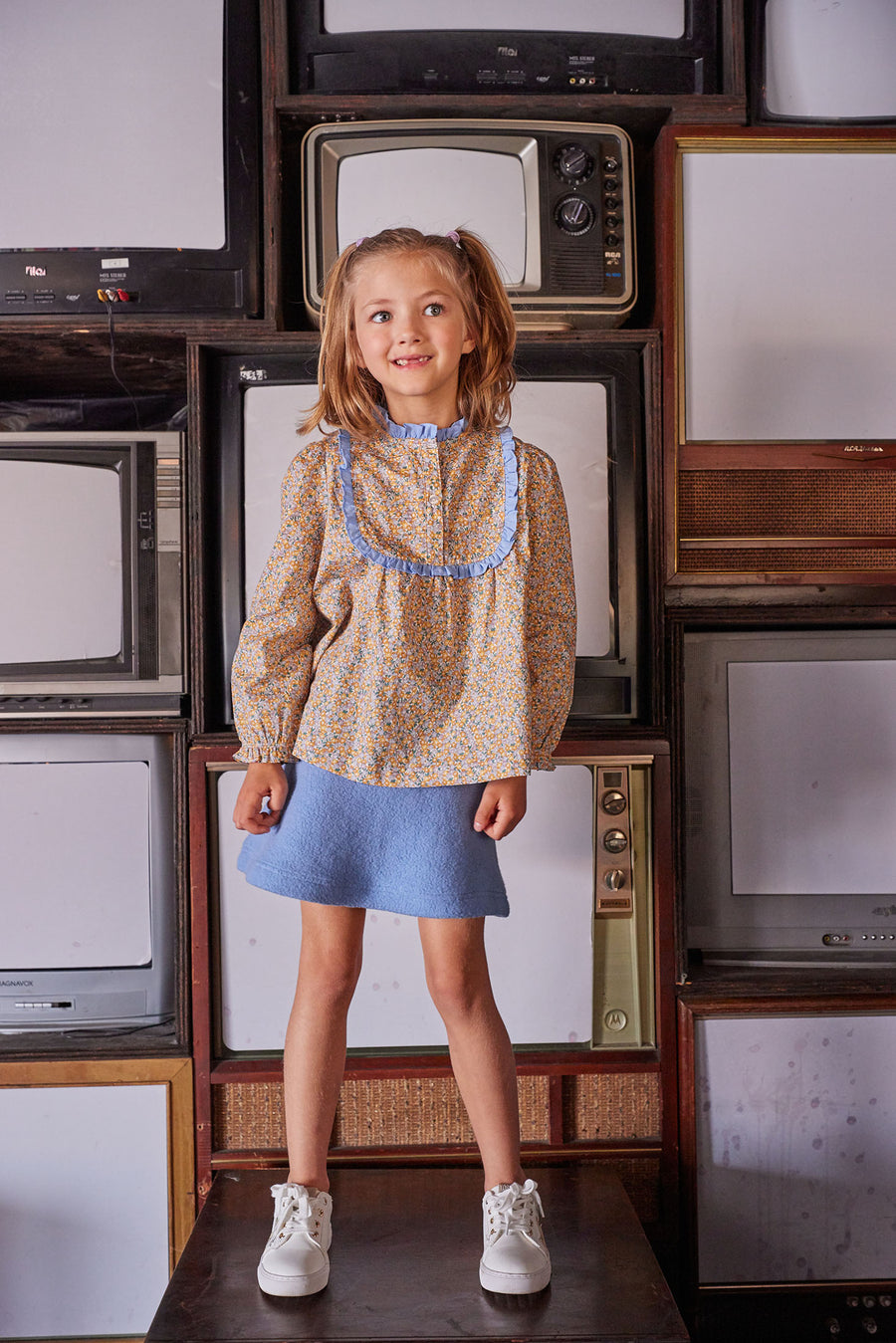 Little girl can be seen wearing our Chelsea Top in our Devon Floral Amber which we have paired with our Mini Skirt in French Blue Sherpa--BISBY girl