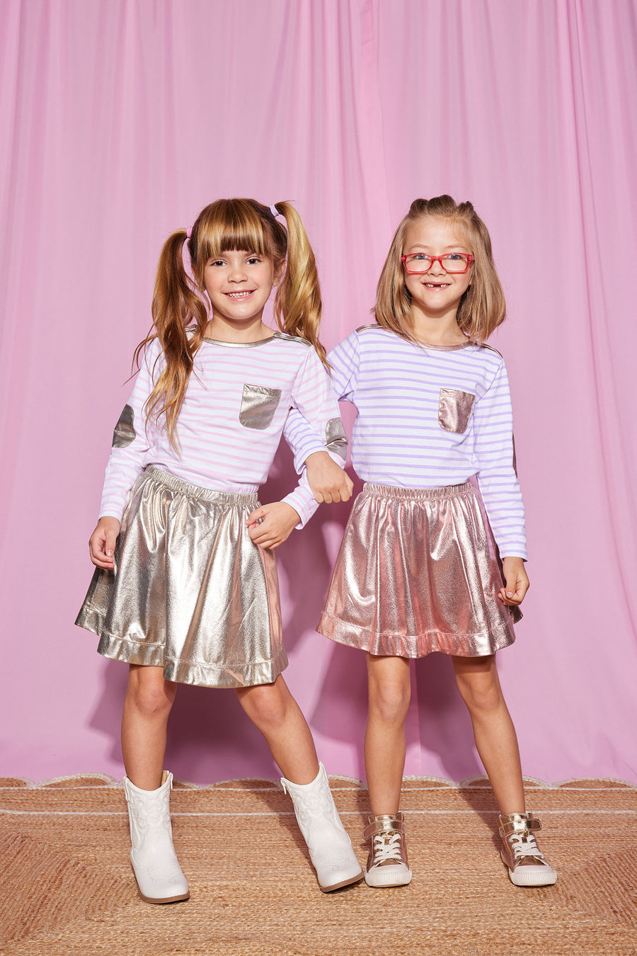 Girls can be seen wearing our Breton Tops in our Pink Stripe (left) and our Lilac Stripe (right). Easily pair these tops with our Circle Skirts in Gold and Pink Lame--BISBY girl