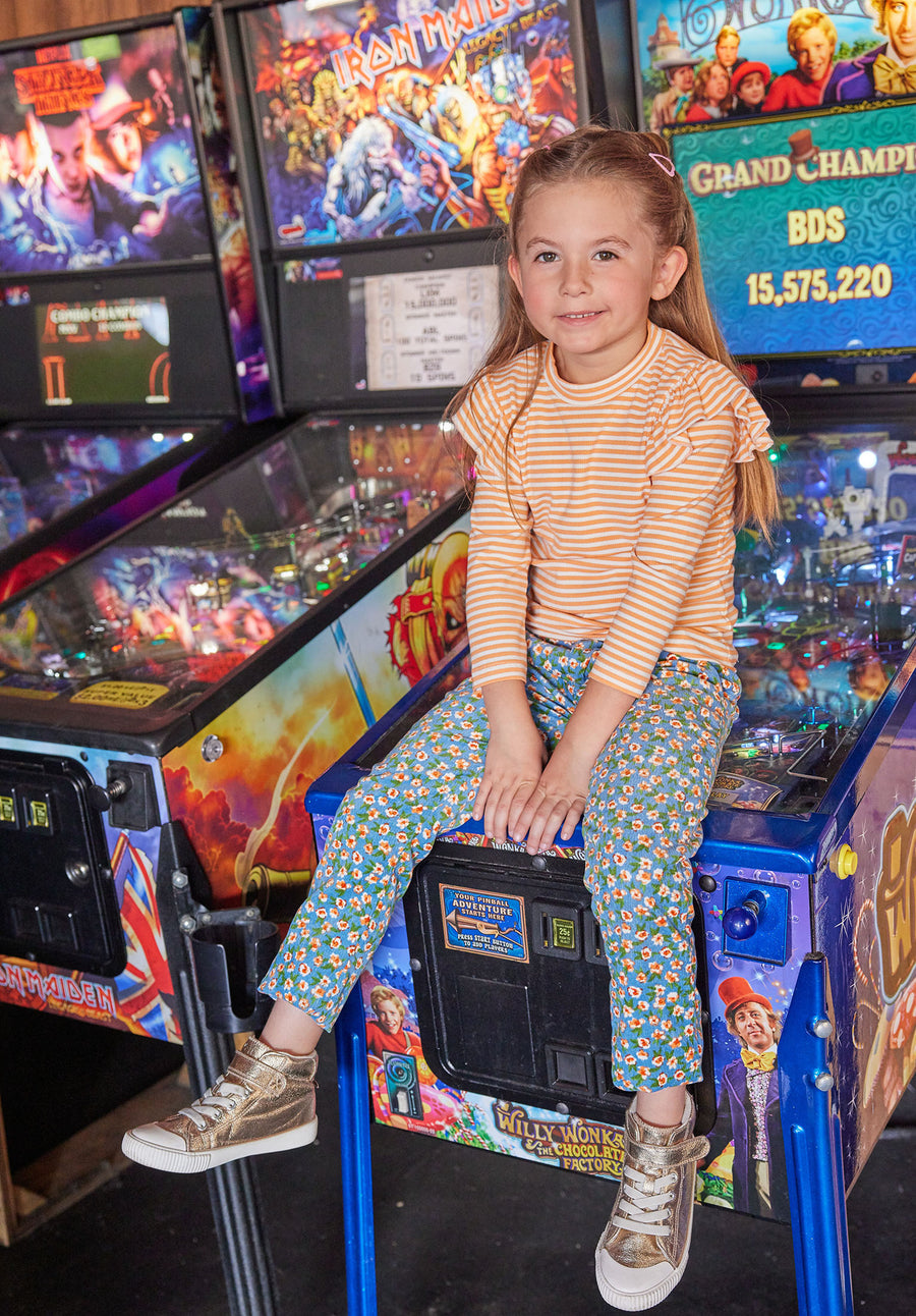 Our little model can be seen wearing our Twiggy Cords in Blue Floral Corduroy which match perfectly with our Orange Sparkle Stripe Sadie Top to complete the look--BISBY girl