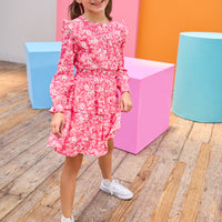 Model can be seen wearing pink/white/red floral woven dress that features an elastic ruched waistband and a two-tiered skirt detail to elevate the dress. 