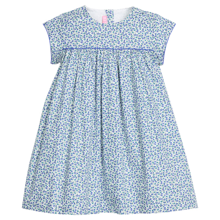 Girls woven short sleeve dress in a blue floral pattern that features button closure at back of neckline. Dress also features a blue trim across bust and end of sleeves for an elevated look. 