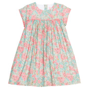 Girls woven dress in a pink/teal/green floral print that features a four button closure along back of dress and a pink trim across the bust and end of sleeves for an elevated look. 