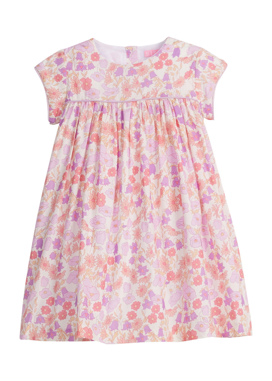 Girls/Tween short sleeve woven dress in a light purple/salmon/pink floral arrangement. Dress also features button closure at back and a light purple trim across the bust and continues at trim of sleeves for a nice extra detail. 