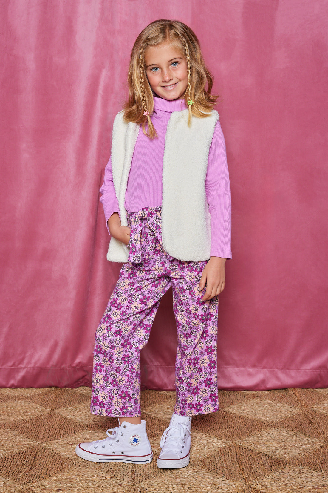 Girls/Tween sherpa/reversible vest in a pink/purple floral arrangement. Vest has one side with a floral print and one side with sherpa to give options to your girl.Pair it back with the matching pant in the same floral print to complete the look.