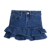 Girls/Tween denim skirt that features a two-tier ruffle at bottom of skirt. Skirt also features a snap button closure and pockets in the front.