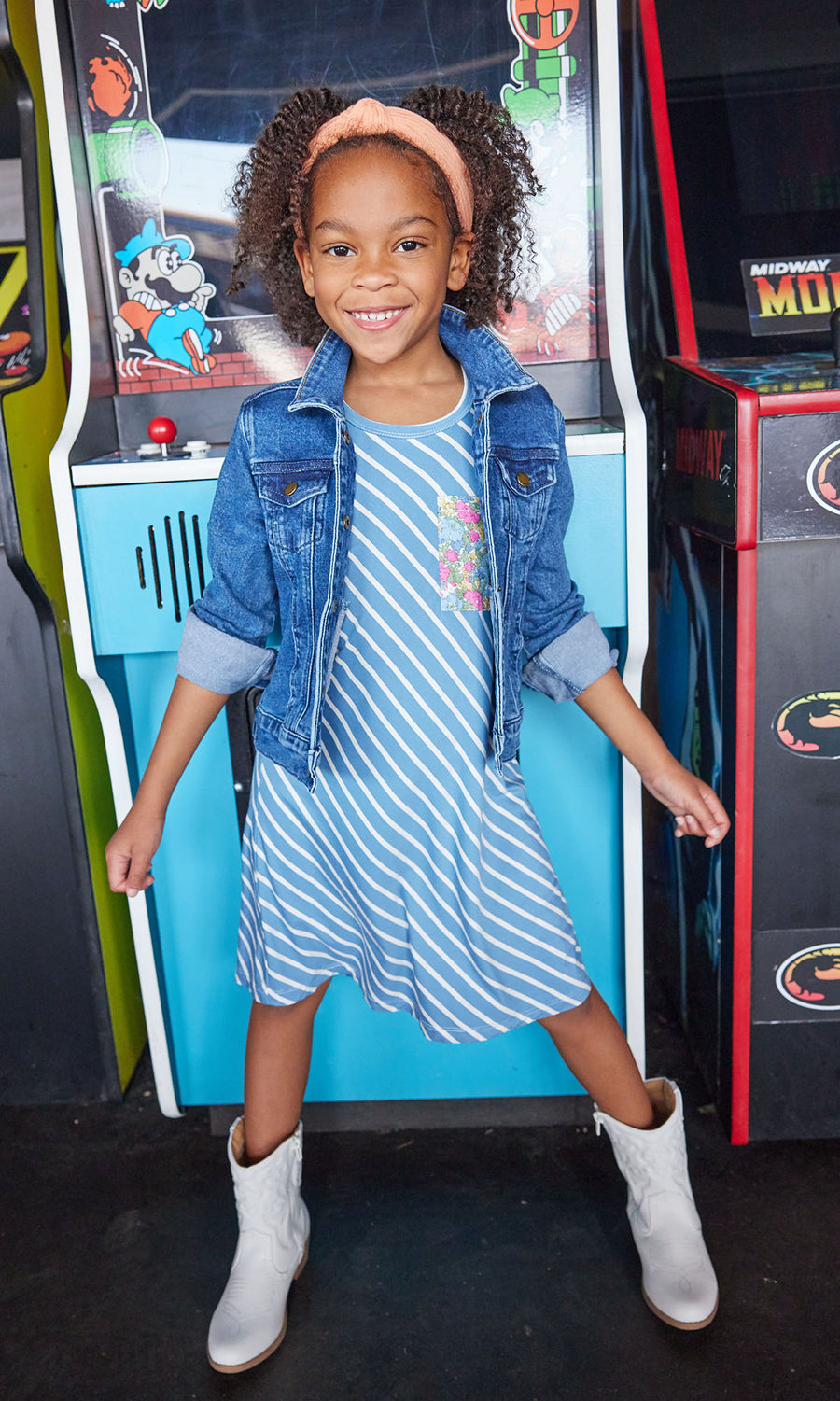 Little girl seen wearing our Everyday Dress in French Blue Stripes/ Merion Floral pocket-paired with our jean jacket--BISBY girls