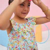 Sleeveless top with scalloped collar and colorful flower pattern.