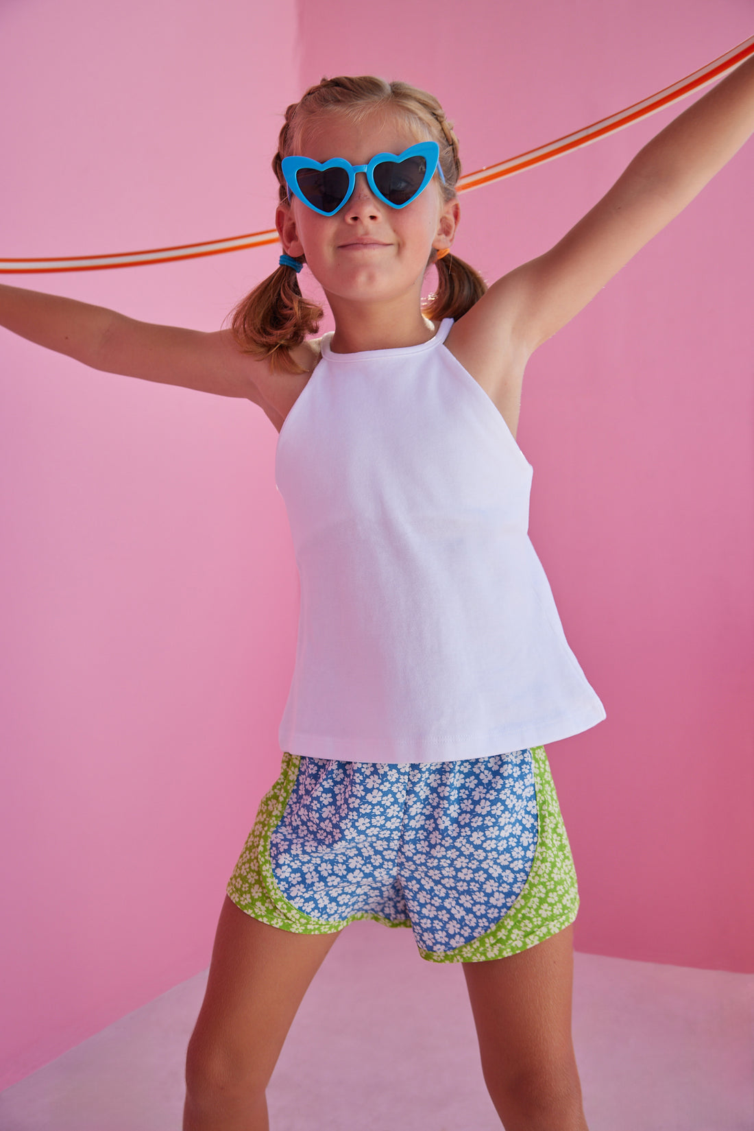 BISBY girl rocking our new track shorts in our Mixed Lawn Floral Pattern. This floral pattern contains blue and green base colors with white floral arrangement all over the shorts. Pair it back perfectly with our white halter top for an active/sporty look.