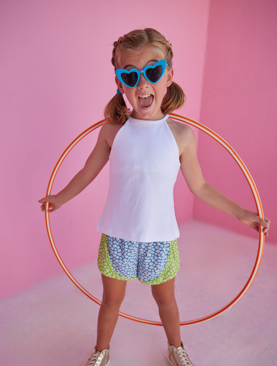 BISBY girl rocking our new track shorts in our Mixed Lawn Floral Pattern. This floral pattern contains blue and green base colors with white floral arrangement all over the shorts. Pair it back perfectly with our white halter top for an active/sporty look.