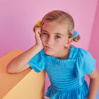 BISBY girl in our India Top in Blue which features ruching/ smocking on the body of the shirt in a super soft rayon material. Shirt is very stretchy but also form fitting and pair perfectly back with our basic shorts in Blue