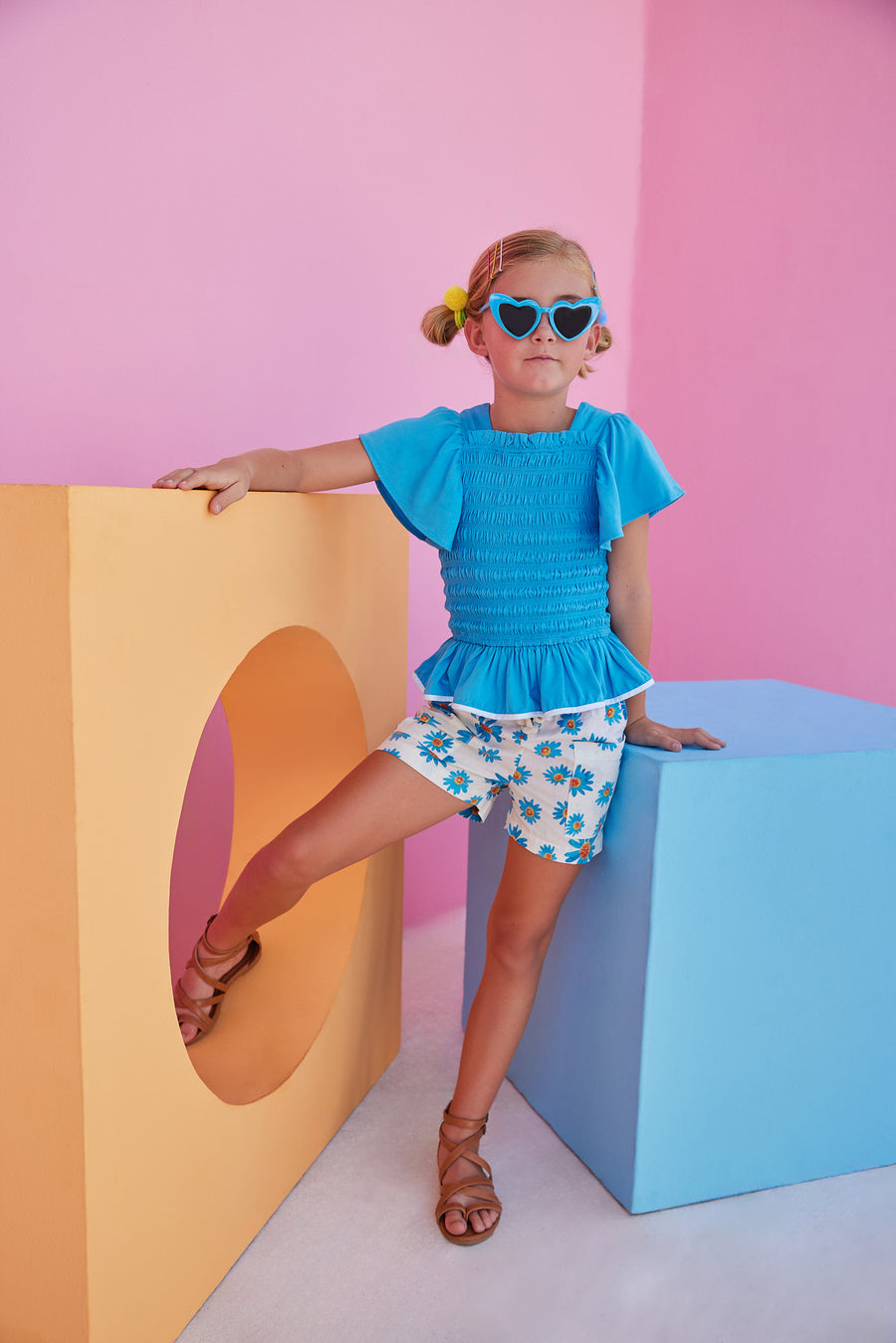 BISBY girl wearing our new Patch Pocket Shorts in our Fenwick Blue floral pattern. These shorts have pockets in the front and fixed ties with an elastic waistband. They pair perfectly back with our India Top in Blue or even our Michaela top in Fenwick Blue for a completed look.