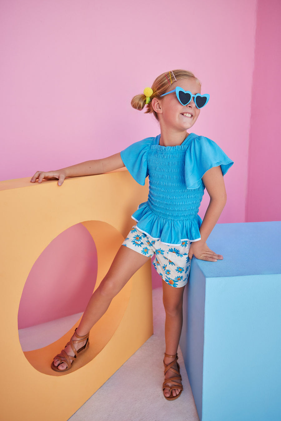 BISBY girl wearing our new Patch Pocket Shorts in our Fenwick Blue floral pattern. These shorts have pockets in the front and fixed ties with an elastic waistband. They pair perfectly back with our India Top in Blue or even our Michaela top in Fenwick Blue for a completed look.