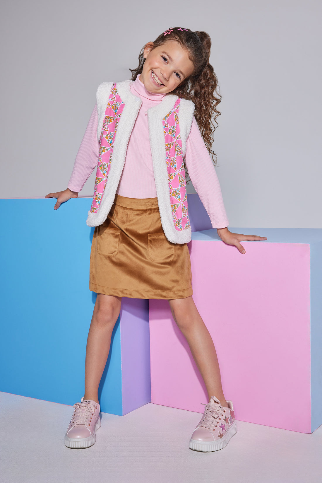 Girls/Tween ribbed turtleneck in a bubblegum pink shade, made of a soft knit material which is a perfect layering piece to go under the reversible vest seen pictured. The other side of the vest is the same material as the brown skirt and so the top two pieces pair nicely with the mini skirt in brown suede to complete the look.