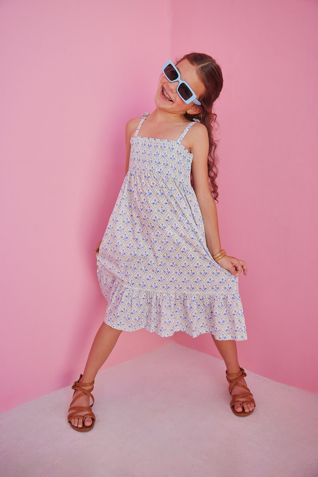 BISBY girl seen in our Lucy Dress in Vintage Azur which features a gorgeous yet simple blue and green floral pattern. This dress has fixed ties on the straps for an elevated look and ruching across the bust for a comfortable yet fitted look.