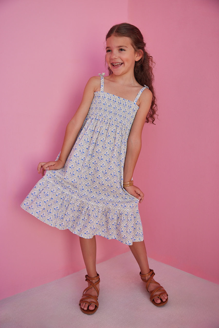 BISBY girl seen in our Lucy Dress in Vintage Azur which features a gorgeous yet simple blue and green floral pattern. This dress has fixed ties on the straps for an elevated look and ruching across the bust for a comfortable yet fitted look.