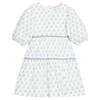 BISBY girl woven white dress in blue/green floral print. Dress features three button closure along back, elastic cuffs at sleeve, and blue ric rac detail across tiers of dress for an elevated look.