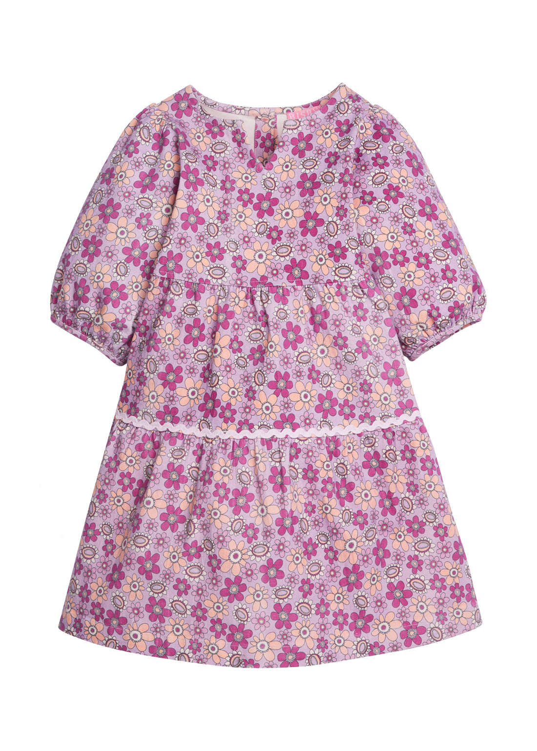 Girls/Tween woven slightly v-neck dress in our Petal floral which features an arrangement of magenta/purple/pink flowers on a light purple background. Dress has a ric rac detail along bottom tier and elastic cuffs on the sleeves. Dress also has button enclosures along the back-BISBY