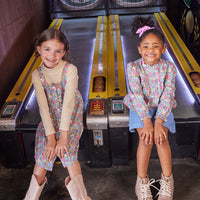 The girls can both be seen wearing our Merion Floral pattern in the top and dress. The top has been paired with our Blue Sherpa Mini Skirt while the dress has been paired with a tan essential turtleneck-- BISBY girl
