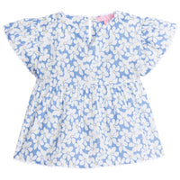 Girl/tween v-neck top with white scallop trim along sleeves and bottom of the top. Has a light blue background with white flowers with yellow centers printed on top. 