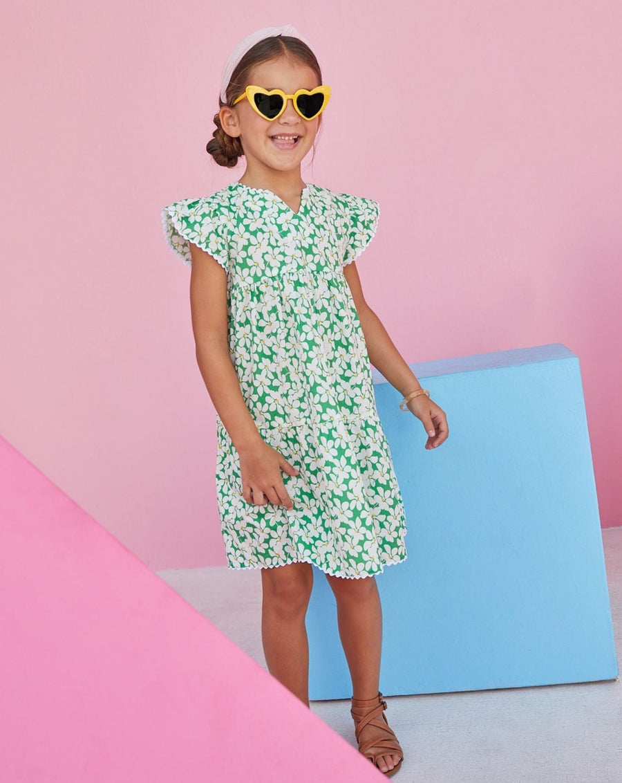 Model wearing sundress for tween girls by BISBY in green, yellow, and white. 