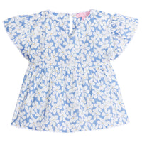 Girl/tween v-neck top with white scallop trim along sleeves and bottom of the top. Has a light blue background with white flowers with yellow centers printed on top.