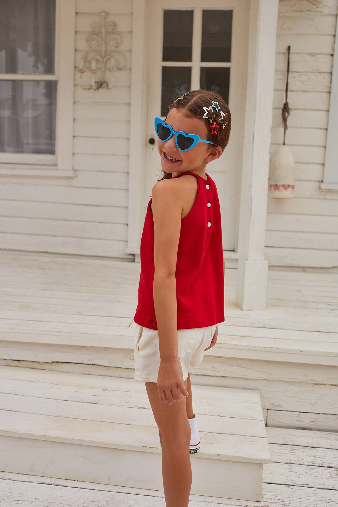 Red halter top with button enclosures on back paired with our denim shorts in ivory. Perfect for a summer or Fourth of July fit.