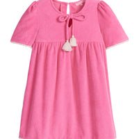 Girls/Tween hot pink terry cloth dress that features a slight v-neckline, light pink pom pom detail at sleeves, and tie tassels at top of neckline. There is also a button closure at back for a relaxed but secure fit. 