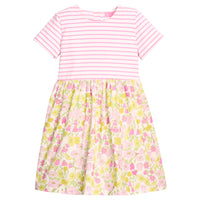 BISBY girl dress in half knit fabric and half woven fabric. The top of the dress is a knit pink and white fabric and the bottom of the dress is a woven pink and yellow floral fabric. Dress features button closure at back as well for a secure but comfy fit.
