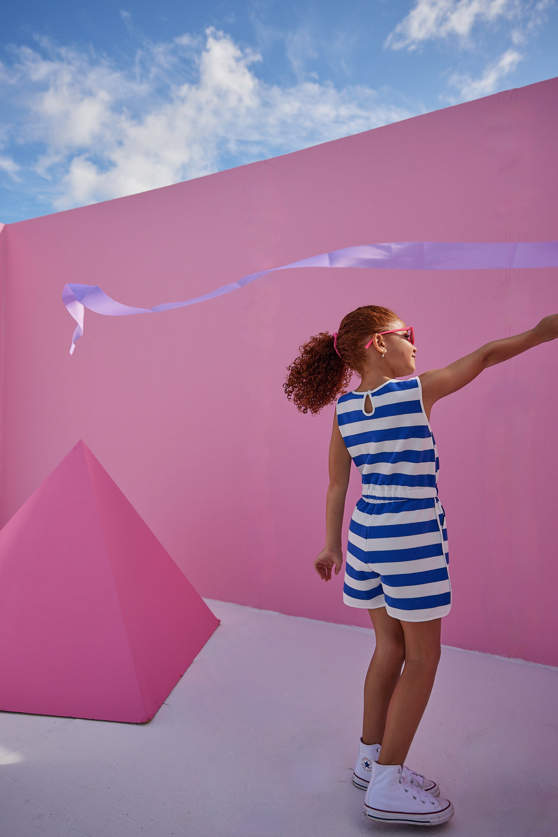 Girl/tween woven romper with pockets and elastic tie waistband with thick royal blue and white stripes.