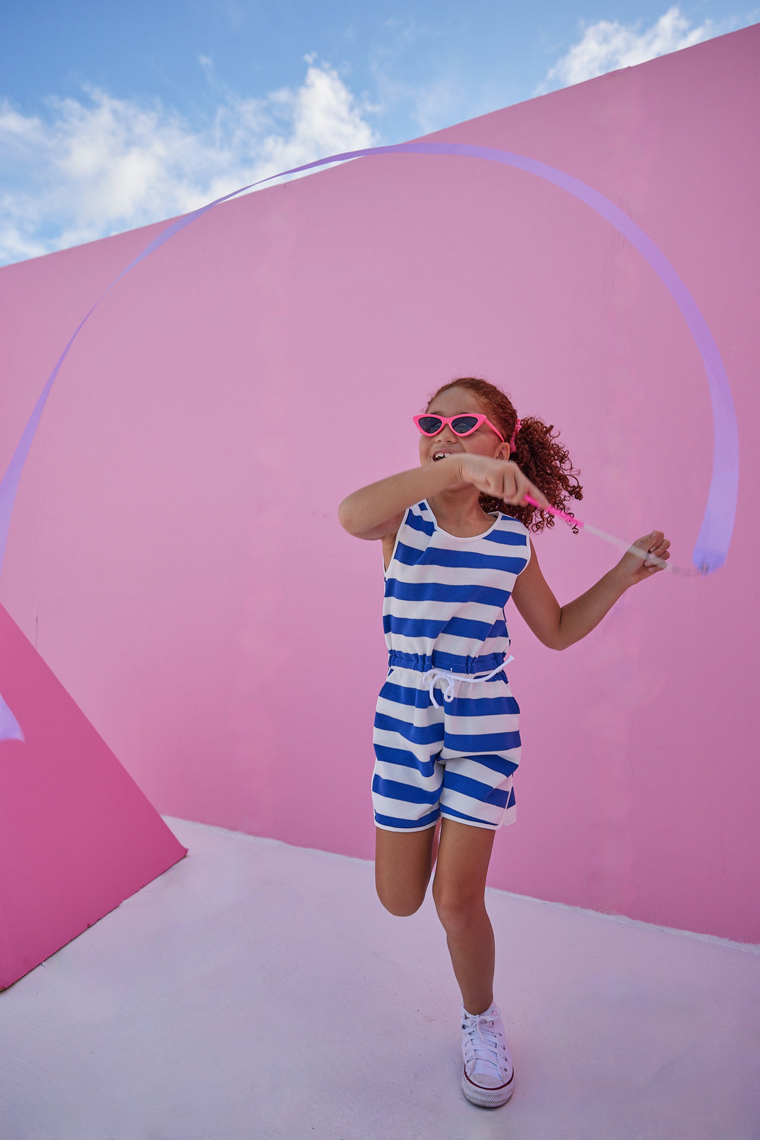 Girl/tween woven romper with pockets and elastic tie waistband with thick royal blue and white stripes.