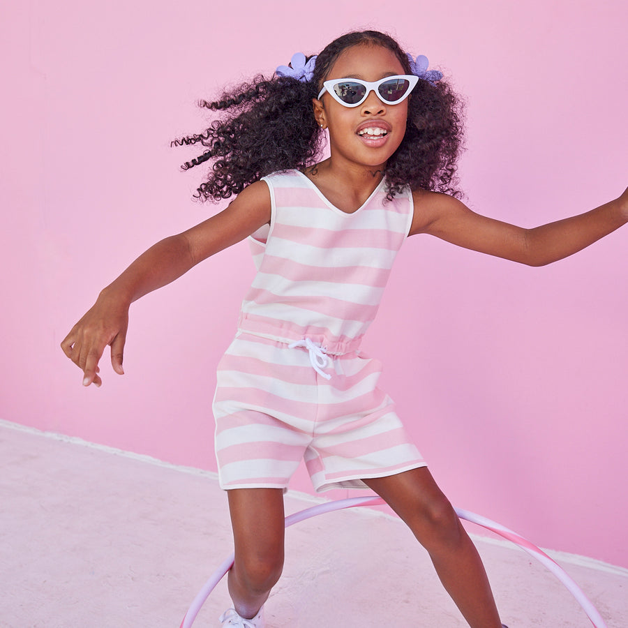 Girl/tween woven romper with pockets and elastic tie waistband with thick light pink and white stripes.