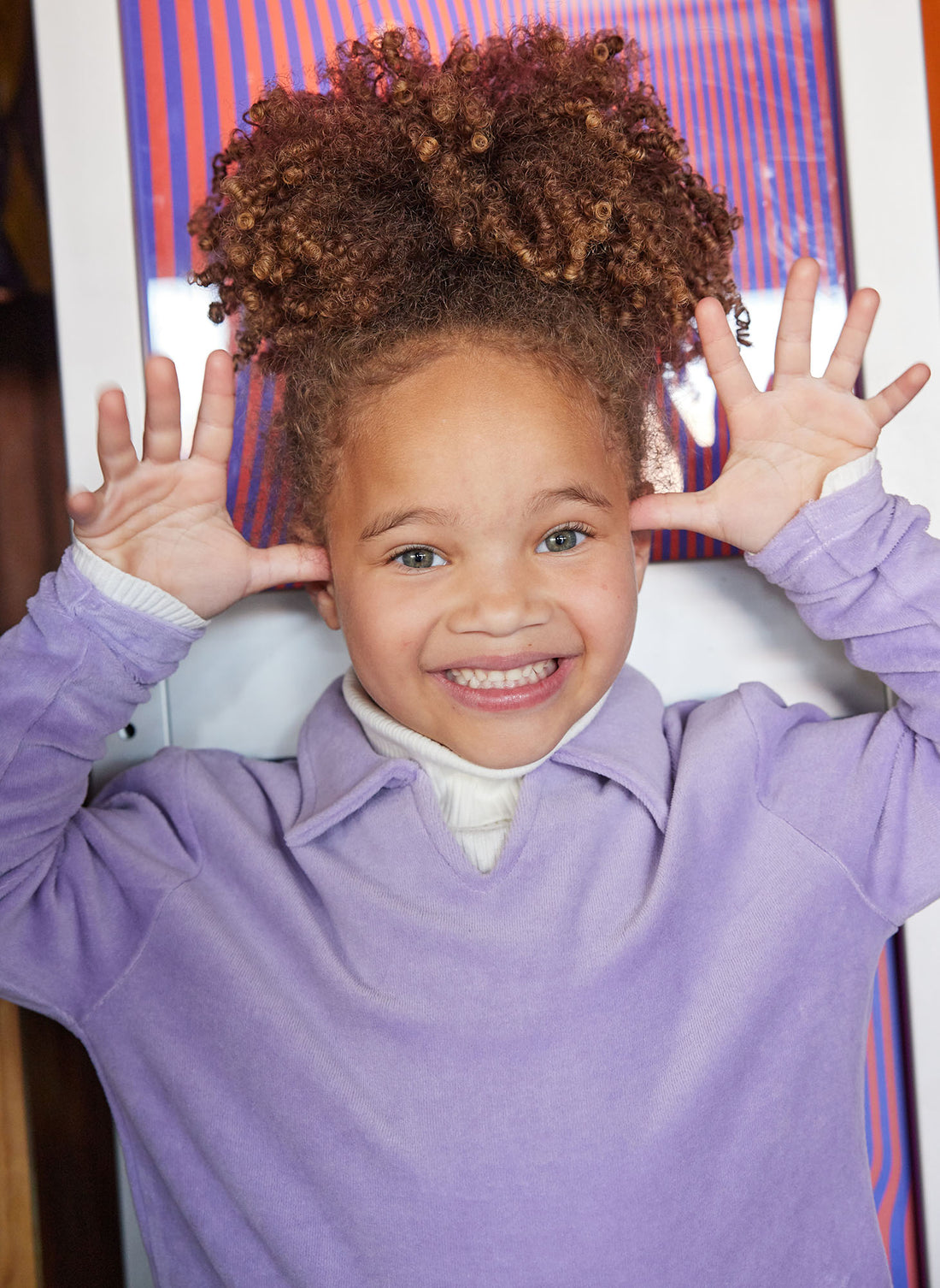 Little girl can be seen wearing our Lilac Polo pullover layered with our Cream colored essential turtleneck underneath--BISBY girl