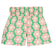 BISBY girl woven shorts with a green and salmon pink floral print. Shorts feature a smocked waistband, pockets, and a scallop bottom hem for an elevated look. 