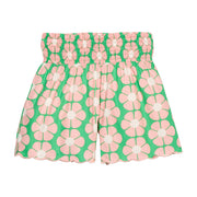 BISBY girl woven shorts with a green and salmon pink floral print. Shorts feature a smocked waistband, pockets, and a scallop bottom hem for an elevated look. 