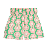 BISBY girl woven shorts with a green and salmon pink floral print. Shorts feature a smocked waistband, pockets, and a scallop bottom hem for an elevated look. 