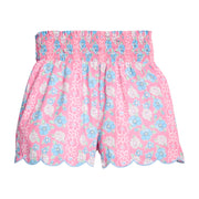 BISBY girl woven white shorts with a pink/blue/white floral print. Shorts feature a smocked waistband, pockets, and a scallop bottom hem for an elevated look. 