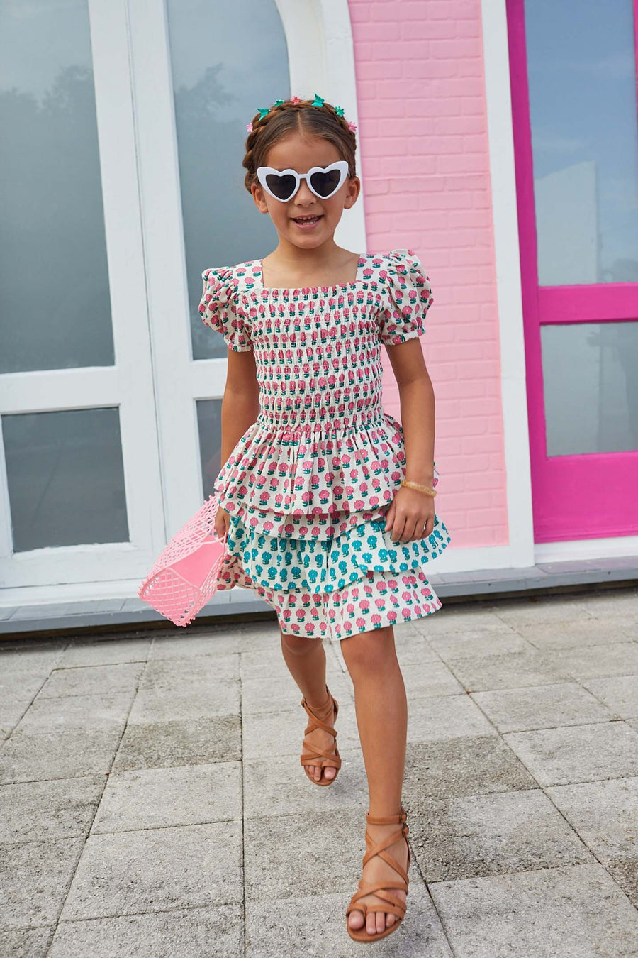 Our model is wearing a tiered skort that features a marigold flower print in alternating pink and turquoise flowers on each tier. 