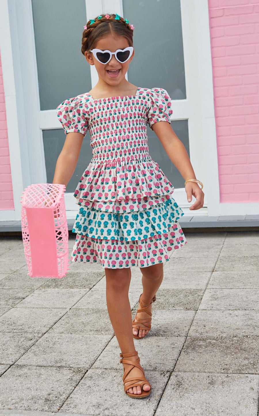 Little girl smiling and wearing our tiered skort with pink and blue flowers alternating colors on each tier. 