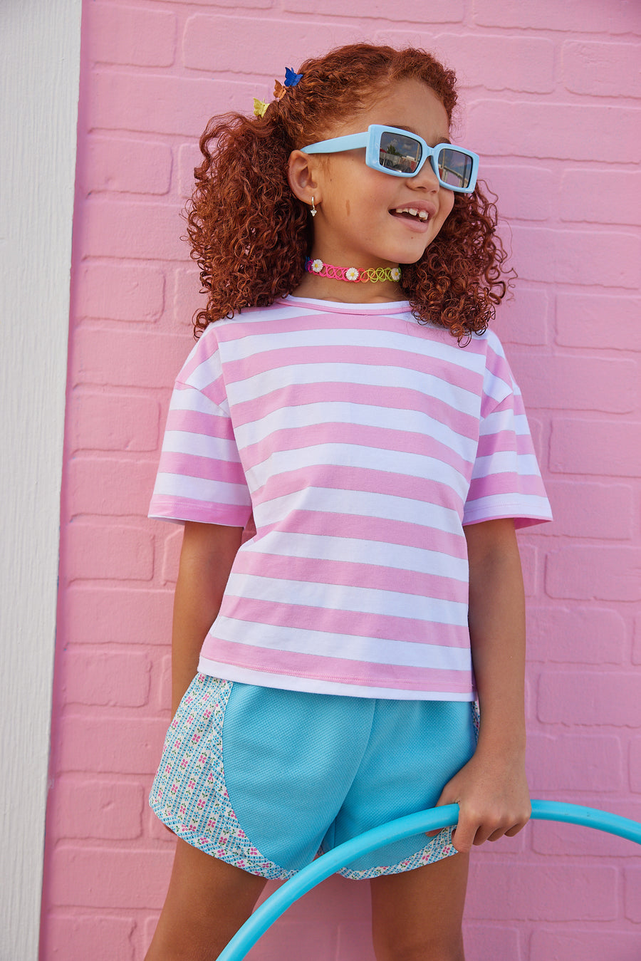 BISBY girl in our Boxy Tee with Pink/White/Silver Metallic Stripe paired with our track shorts in our blue daisy chain. 