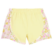 BISBY girl knit yellow track shorts with woven yellow and pink floral print detail along sides of shorts. Shorts feature an elastic waistband as well for a secure but relaxed fit. 