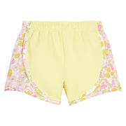 BISBY girl knit yellow track shorts with woven yellow and pink floral print detail along sides of shorts. Shorts feature an elastic waistband as well for a secure but relaxed fit.