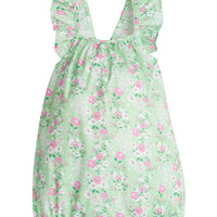 Baby girl bubble with adjustable ruffle straps and elastic along leg openings. Has a light pink and white floral print on top of a light green background.