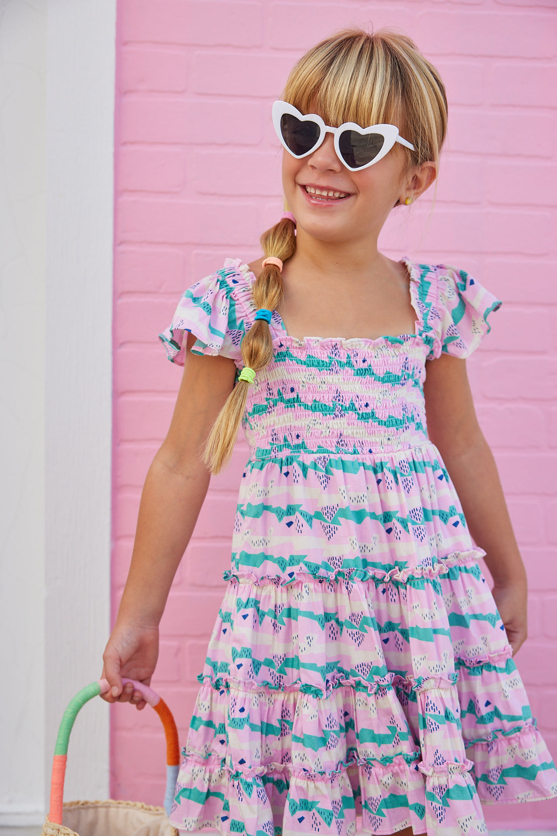 BISBY girl in our new Twirl Dress in our Alli Stripe. This dress features smocking on the bust and has angel sleeves for a more elevated look. Made from a super soft material, this pink/green/ and cream dress is the perfect, comfortable, flowy dress for summer.